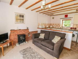 a living room with a couch and a fireplace at Chestnut Cottage in Great Edston