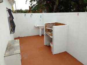a bathroom with a sink and a white wall at Mio Nonno Mia Nonna II in San Clemente del Tuyú