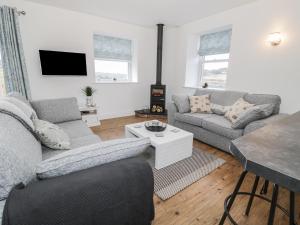 a living room with two couches and a table at Shepherds Cottage in Rothbury