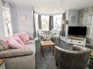 ein Wohnzimmer mit einem Sofa und einem TV in der Unterkunft Manor Heath Apartment 4 in Scarborough