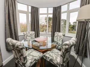 een eetkamer met een glazen tafel en 2 stoelen bij Manor Heath Apartment 4 in Scarborough