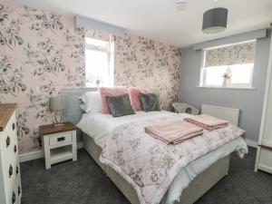 een slaapkamer met een bed met roze en grijs behang bij Manor Heath Apartment 4 in Scarborough