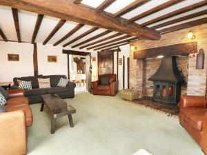 a living room with a couch and a fireplace at Harbourne Oast in Tenterden