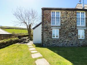 a brick house with a picnic table in front of it at Atlantic View in Tintagel