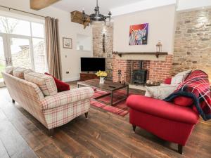 a living room with two chairs and a fireplace at The Turnip Barn in Durham