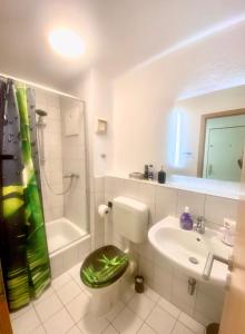 La salle de bains est pourvue de toilettes, d'un lavabo et d'une douche. dans l'établissement Apartment im Stadtzentrum mit W-LAN und Netflix Home Sweet Home, à Fürth