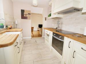 a kitchen with white cabinets and a stove top oven at The Lodge in Brandon +16 photos