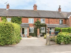 a red brick house with a gate in front of it at Callow Cottages in Ashbourne
