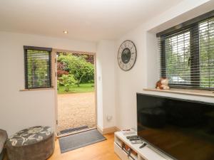 a living room with a large flat screen tv at Pump House in Horam