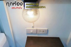 a light on a wall next to a lightswitch at โรงแรมบาบาราย in Si Sa Ket