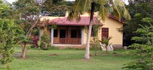 a house with a red roof and palm trees at Villa De Lagoon View in Tangalle