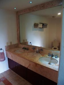 bagno con lavandino e grande specchio di Beachfront Apartment Your Home in Cozumel a Cozumel