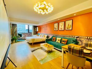 Huangshan Sky Small Nest B&B في هوانغشان: غرفة معيشة مع أريكة خضراء وسرير