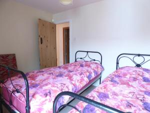 two twin beds in a room with a door at Hall End Barn in Buxton