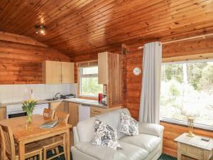 a living room with a couch and a table at Otter Lodge in Strathpeffer