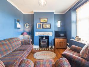 a living room with a couch and a fire place at Bobbin Cottage in Matlock