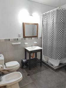 a bathroom with a toilet a sink and a bath tub at Chill Inn Hostel in Mendoza