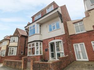 a red brick house with white windows at Mayfield Sands in Bridlington