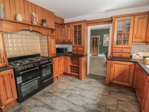 a kitchen with wooden cabinets and a stove top oven at Mayfield Sands in Bridlington