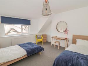 ブリドリントンにあるMayfield Sandsのベッドルーム1室(ベッド2台、テーブル、鏡付)