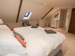 a bedroom with a large white bed in a attic at The Bothy, 21 West Street in Malton