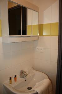 ein weißes Badezimmer mit einem Waschbecken und einem Spiegel in der Unterkunft Résidence d'Artagnan in Montargis