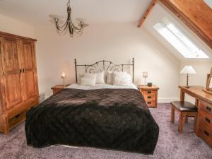 una camera da letto con un letto, una scrivania e una finestra di New Stable Cottage a Danby