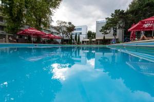 - une piscine d'eau bleue et de parasols rouges dans l'établissement Cocor Spa Hotel, à Legian