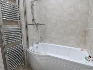 a bathroom with a white tub and a shower at Flat 4 in Whitby +9 photos
