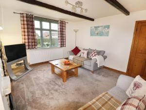 a living room with a couch and a tv at Chippers Cottage in Woodhall Spa