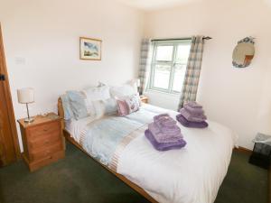 a bedroom with a bed with towels on it at Chippers Cottage in Woodhall Spa