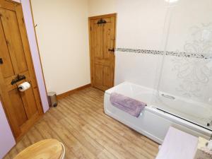 a bathroom with a bath tub and a shower at Chippers Cottage in Woodhall Spa +28 photos