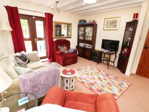 een woonkamer met een bank en een tv bij Emily's Retreat at the Great Barn in Great Dunham
