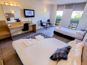 Habitación de hotel con 2 camas y escritorio en Sandors Motor Inn en Mildura