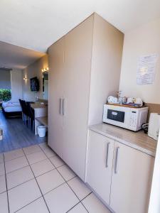 a kitchen with white cabinets and a microwave at Sandors Motor Inn in Mildura