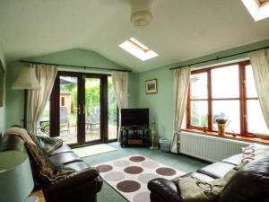 a living room with a couch and a television at Kingsley Cottage in Hickling