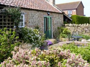 a brick house with a green door in a garden at The Sun House in Ferrensby