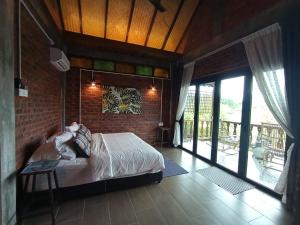 منتجع ذا داون لانغكاوي في بانتايْ سينانج: غرفة نوم بسرير وجدار من الطوب