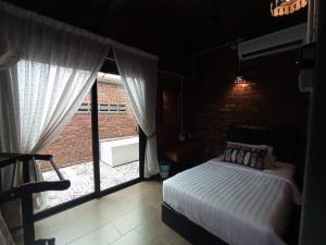 a bedroom with a bed and a large window at The Daun Resort Langkawi in Pantai Cenang