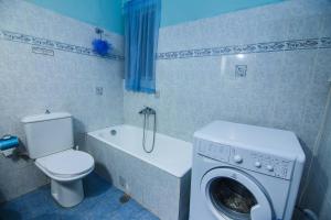 a bathroom with a toilet and a washing machine at Antonio's Guest House in Athens