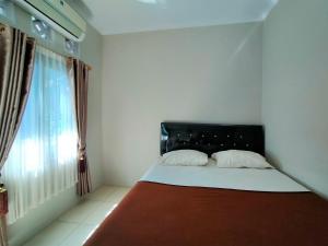 a bed in a room with a large window at Aqsa Guest House Ciamis Syariah in Ciamis