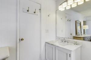 uma casa de banho branca com um lavatório e um espelho em Bounty em Ocean City