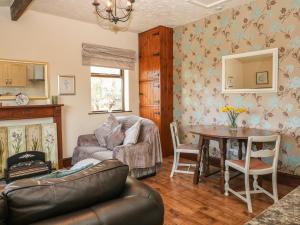 a living room with a couch and a table at The Cottage at Moseley House Farm in Chinley