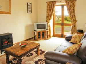 a living room with a couch and a tv at Croft Granary in Stillington