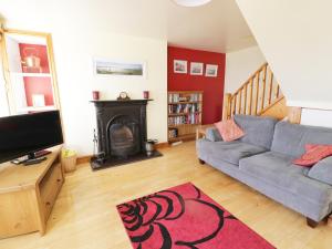 a living room with a couch and a fireplace at Snowdon View in Holyhead