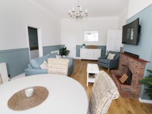 a living room with a couch and a fireplace at Flat 1, Cambridge Court in Frinton-on-Sea