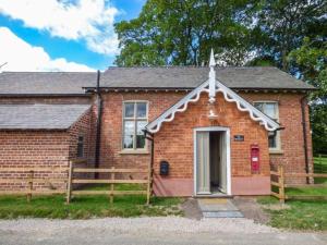 a small brick house with a cross on top of it at The Old School in Panton