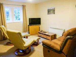 a living room with a couch and chairs and a tv at Jay's Nest in Eyam