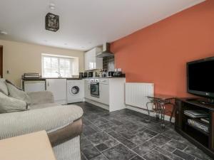 Una sala de estar con un sofá y una cocina. en Church Farm Annex, en Ripon