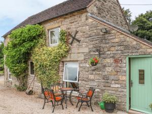 a stone cottage with chairs and a table in front of it at The Cottage in Calton